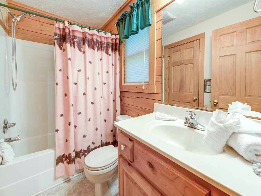 A bathroom with a shower, toilet, and sink.