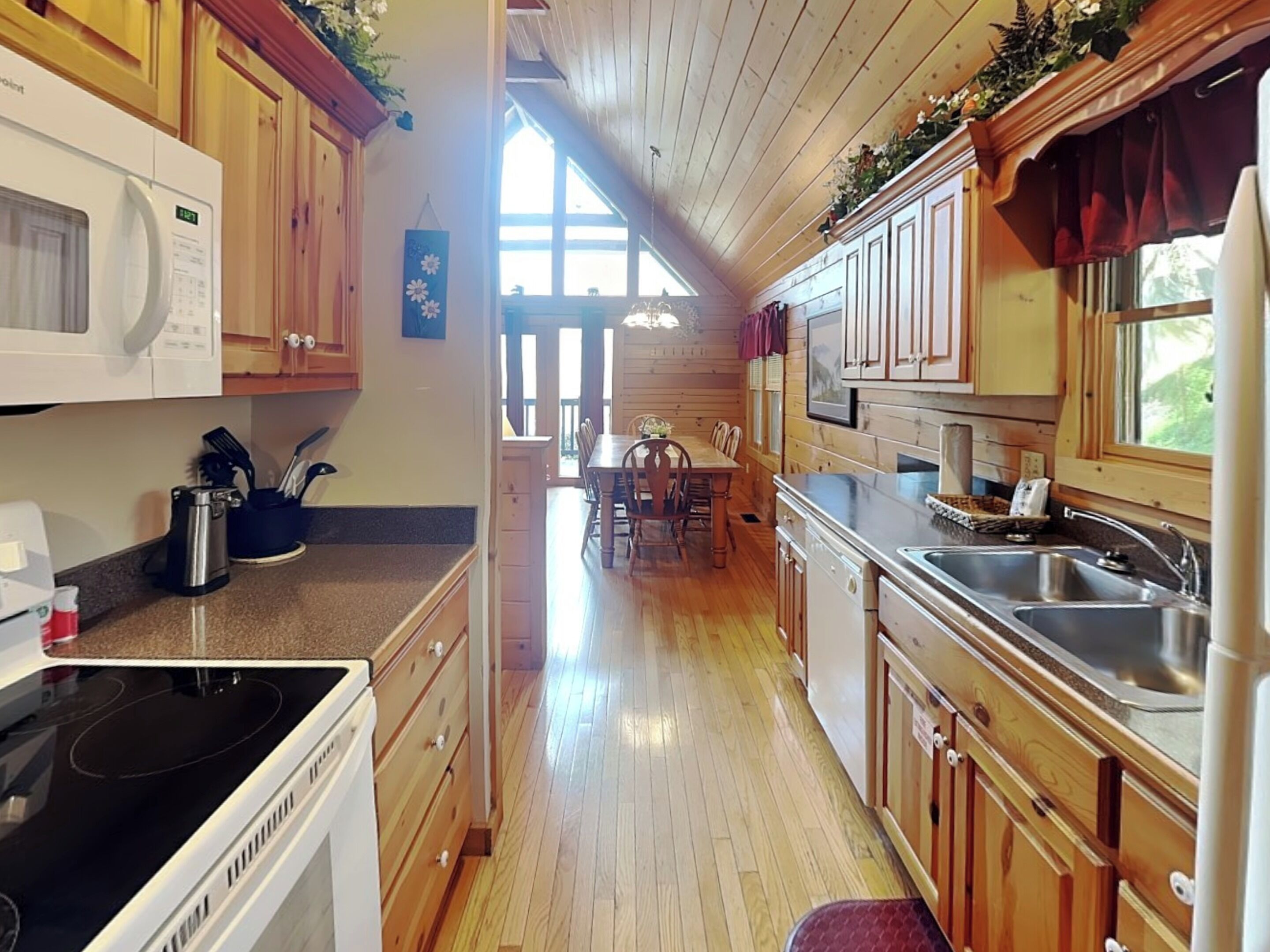 A kitchen with wooden cabinets, a microwave, a stove, and a sink.