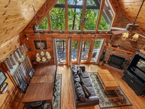 A cozy cabin interior with a dining area, sofa, and fireplace. - Komfy Kozy by Jackson Mountain Rentals (Gatlinburg)