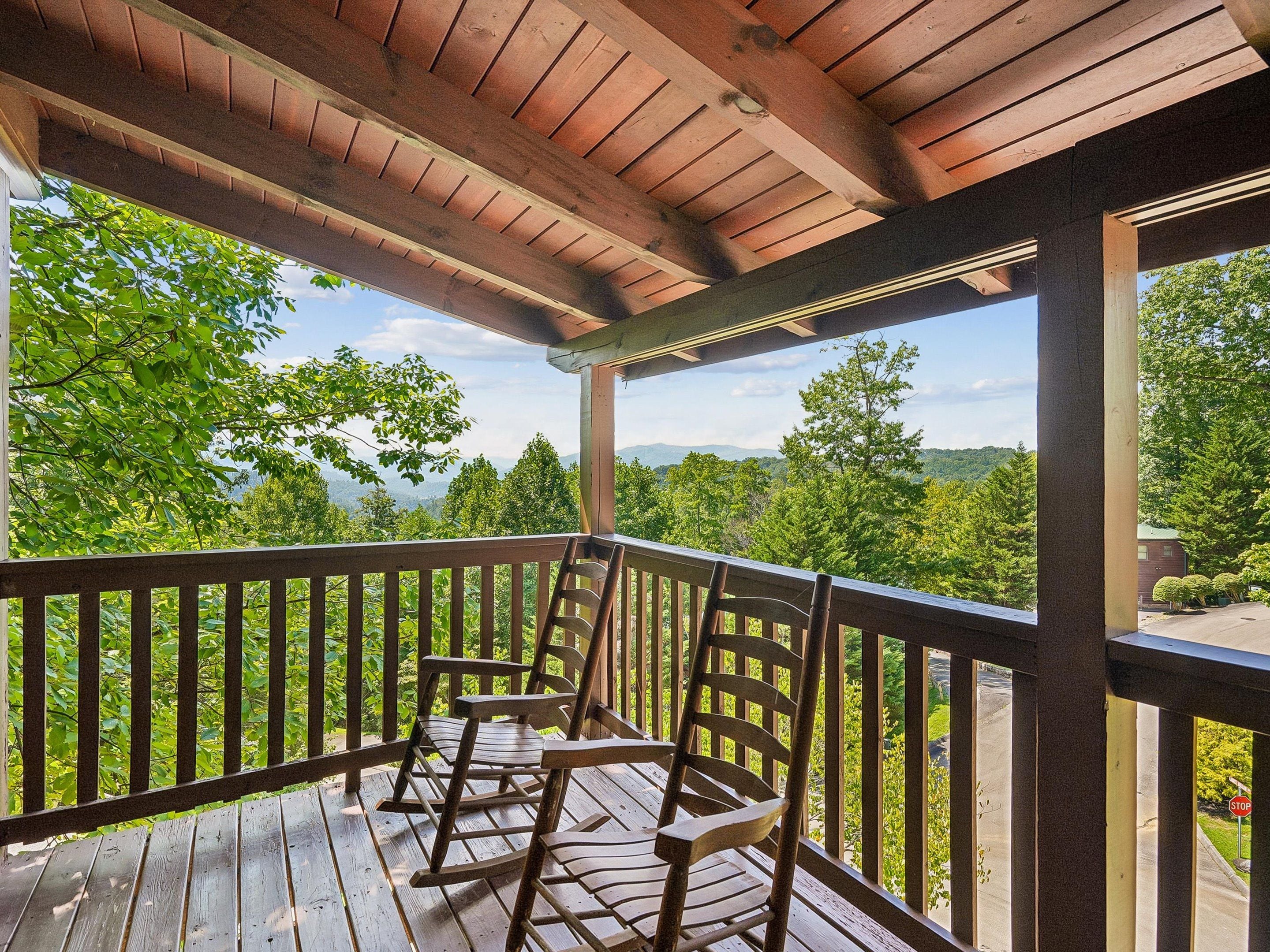 A wooden deck with a view of a mountainous landscape.