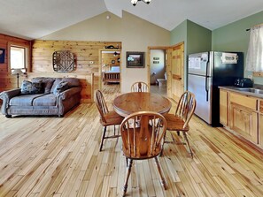 Relax in this inviting room with a comfortable sofa, dining table, and modern kitchen.