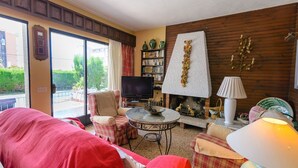 Una sala de estar acogedora con chimenea, televisor y estantería.