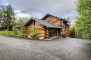 A log cabin with a garage and a covered porch.