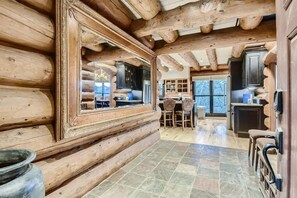 A log cabin interior with a dining area, kitchen, and large windows. - Private Hot Tub in Amazing Home Away From Home! (Silverthorne)