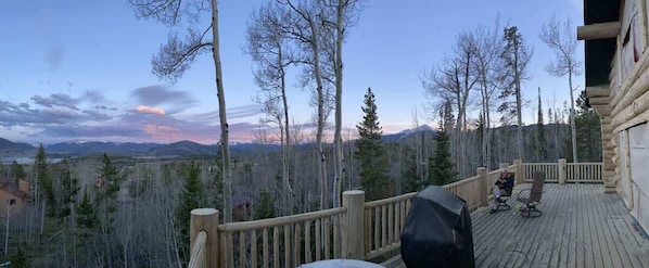 Eine Holzterrasse mit Blick auf Berge und Bäume.