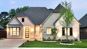 A two-story house with a stone facade, a well-maintained lawn, and a driveway. - Entertainment District: Game Room Hot Tub Putting Green 4 Baths Walk to Stadiums (Arlington,)