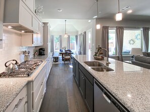 Enjoy cooking in this well-equipped kitchen with a granite countertop, stainless steel appliances, and ample storage.