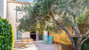 A patio with wooden deck, outdoor furniture, and a wooden fence.