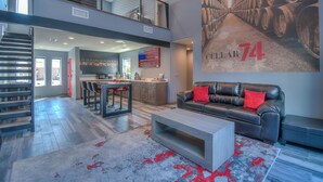A spacious living area with a high ceiling, a staircase, a kitchen, and a dining area. - Cellar 74: New Modern Wine Casita w/Hot tub (Albuquerque)