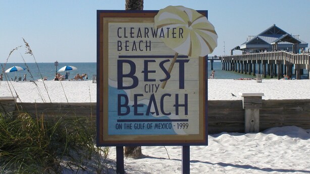 Een strandbord met de tekst 'CLEARWATER BEACH BEST CITY BEACH ON THE GULF OF MEXICO - 1999'.