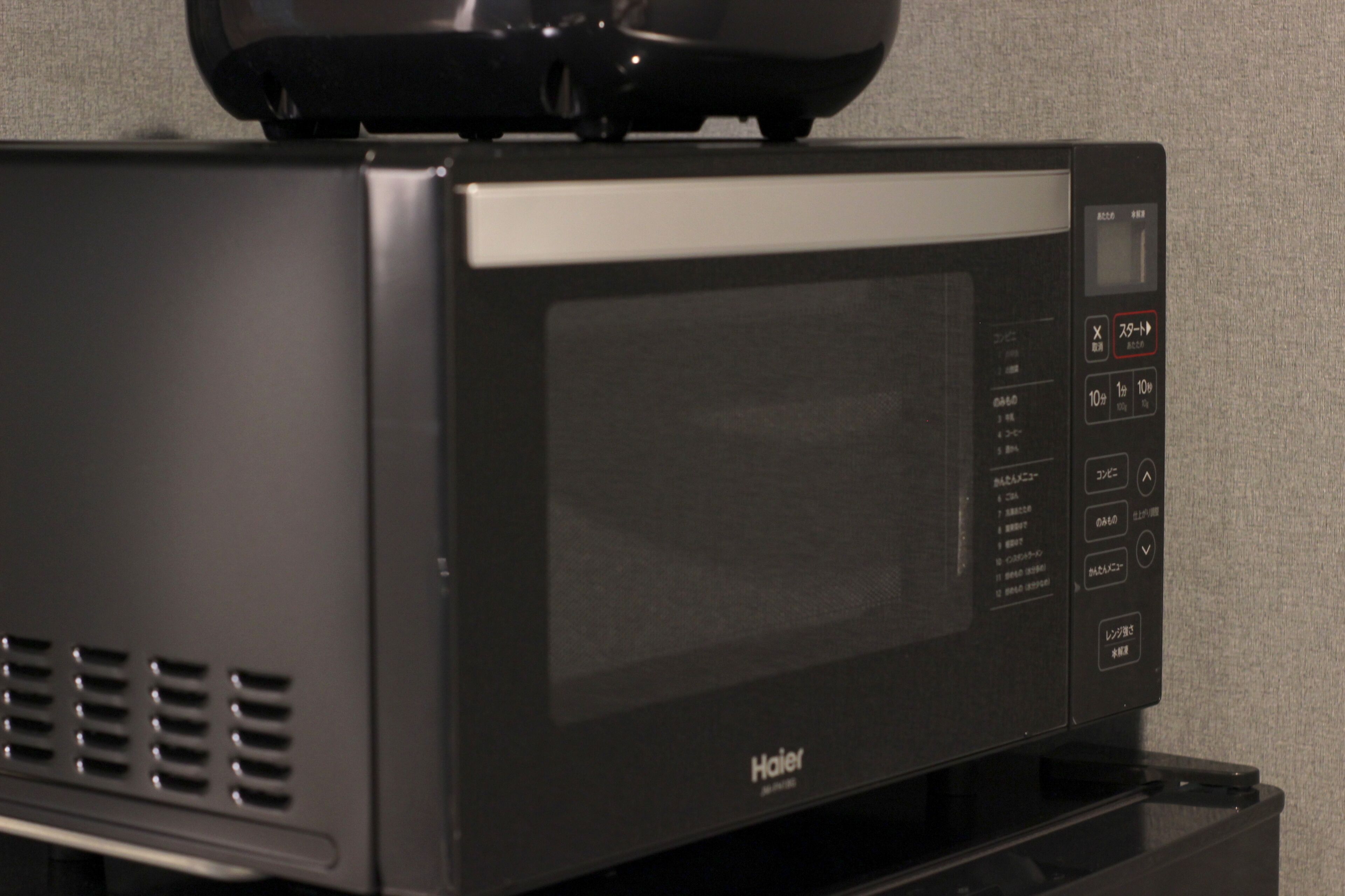 A black Haier microwave oven with a digital display and control panel.