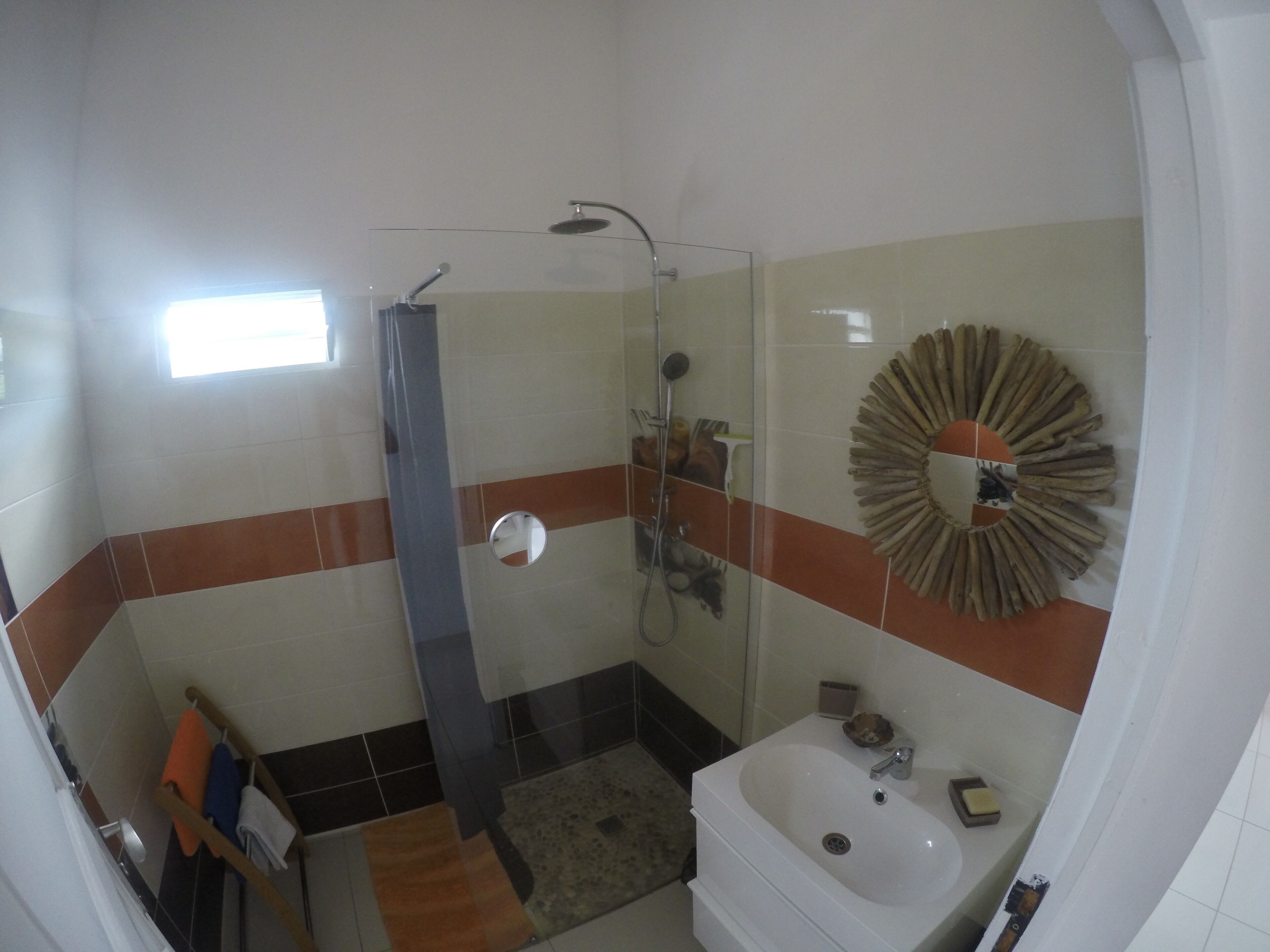 Ein Badezimmer mit Dusche, Waschbecken und Spiegel.