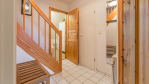 Un escalier avec des rampes en bois menant à une pièce dotée d’une porte blanche et d’un miroir.