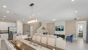 Una cocina moderna con una isla central, electrodomésticos de acero inoxidable e iluminación empotrada.