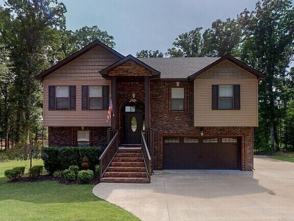 A two-story house with a front entrance, a garage, and a well-maintained lawn.