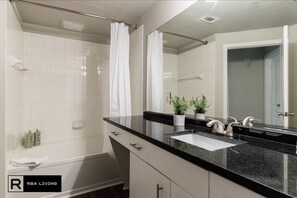 Combined shower/bathtub, deep-soaking bathtub, hair dryer, towels - Uptown CityPlace Apartments X RBA Living (Dallas)