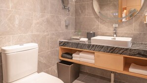 A modern bathroom with a toilet, sink, and mirror. - Holiday Inn Xi’an High Tech Zone by IHG (Xi'an)