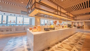 A modern hotel lobby with a marble reception desk, a coffee station, and a view of the city through large windows. - Holiday Inn Xi’an High Tech Zone by IHG (Xi'an)