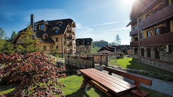 A traditional chalet-style building with a wooden deck and a stone pathway.