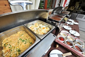 Una mesa de buffet con diferentes alimentos y utensilios.