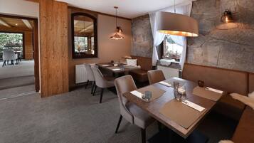 Un espace de restauration moderne avec un mur en pierre, des poutres en bois et une grande fenêtre.