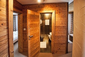 A wooden interior with a narrow hallway leading to a bathroom and a bedroom. - Aplend Kukucka Mountain Hotel & Residences (Vysoké Tatry)