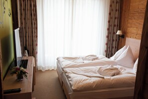 A hotel room with a bed, a TV, a remote control, and a lamp. - Aplend Kukucka Mountain Hotel & Residences (Vysoké Tatry)