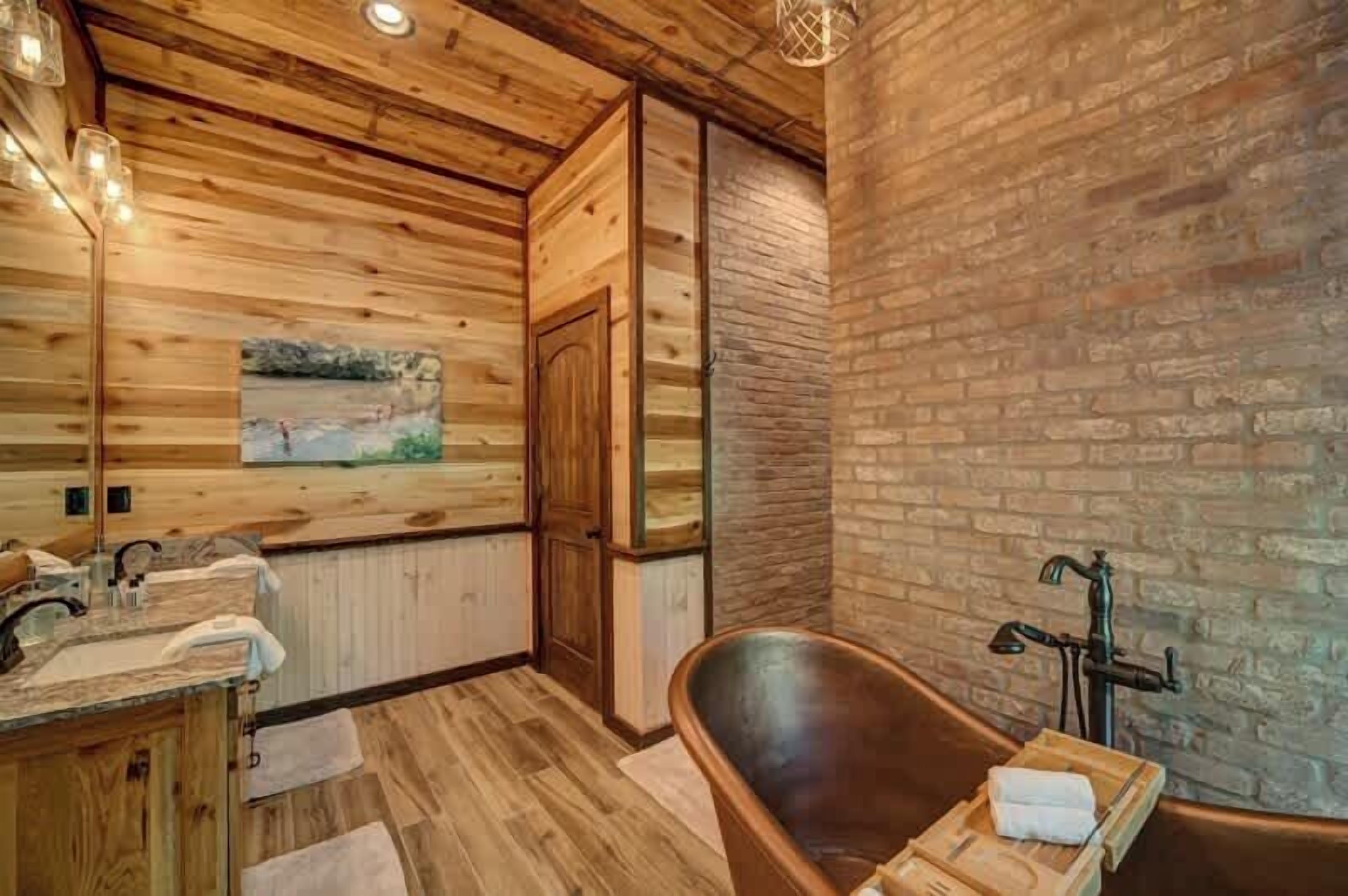 A wooden interior with a bathtub, wooden walls, and a painting.
