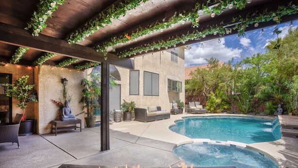 A pool area with a fire feature, outdoor seating, and greenery. - Extraordinary Private Pool/Spa Villa w/man cave (Henderson)