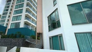 Um edifício moderno de vários andares com fachada branca e janelas grandes.