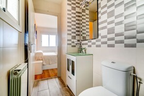 A narrow bathroom with a toilet, a sink with a glass top, and a radiator. - Holiday Home in Redondela with Sea Views (Chapela)