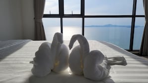 A bed with a view of the sea through large windows. - The Andromeda Condominium (Pattaya)