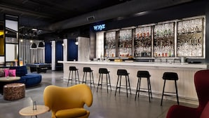 Un área de bar moderna con un letrero de neón, taburetes y una mesa de billar.