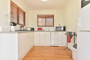 A kitchen with white cabinets, a microwave, a toaster, and a dishwasher.