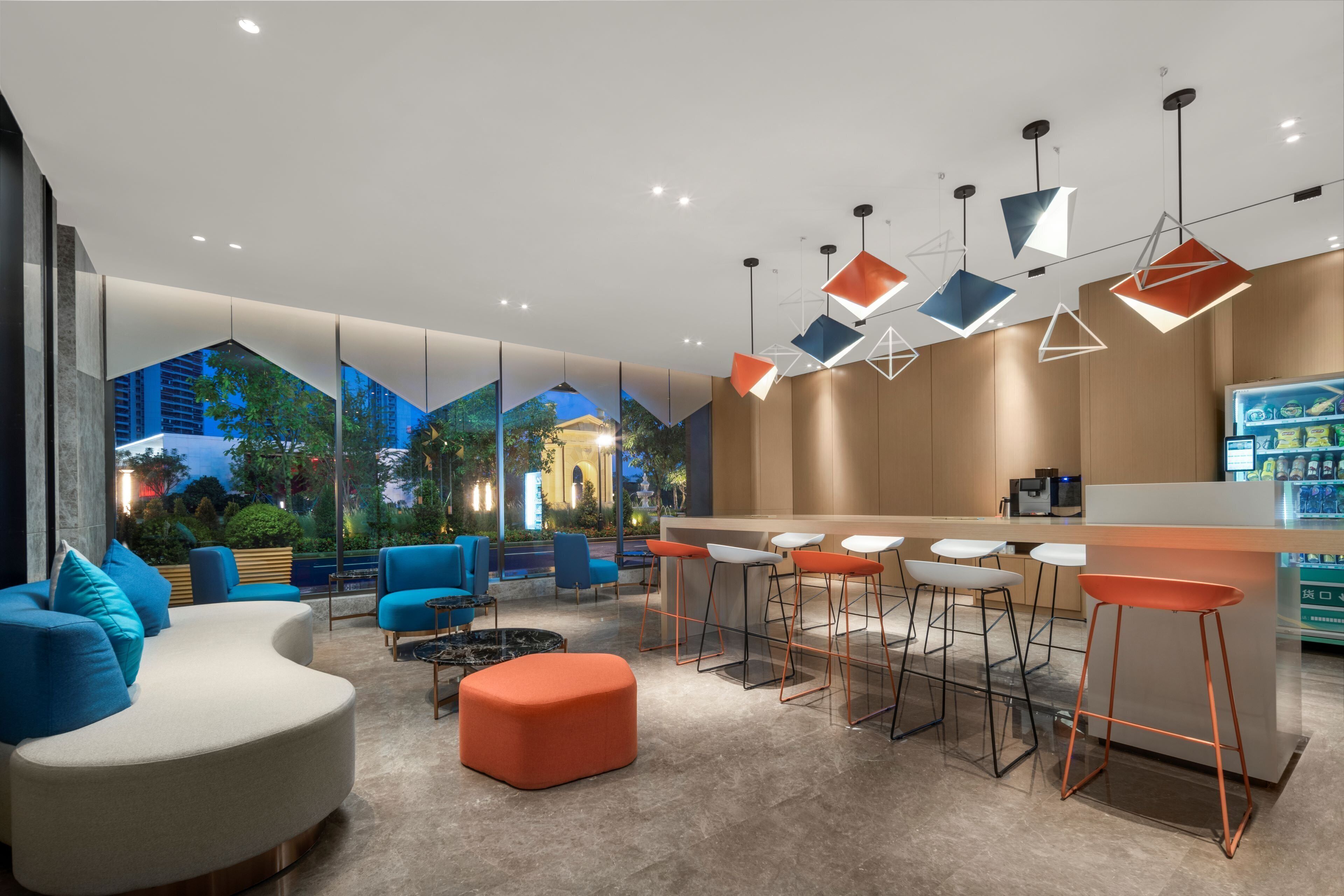 A modern bar area with a bar counter, seating with stools, and a large window with a cityscape view.