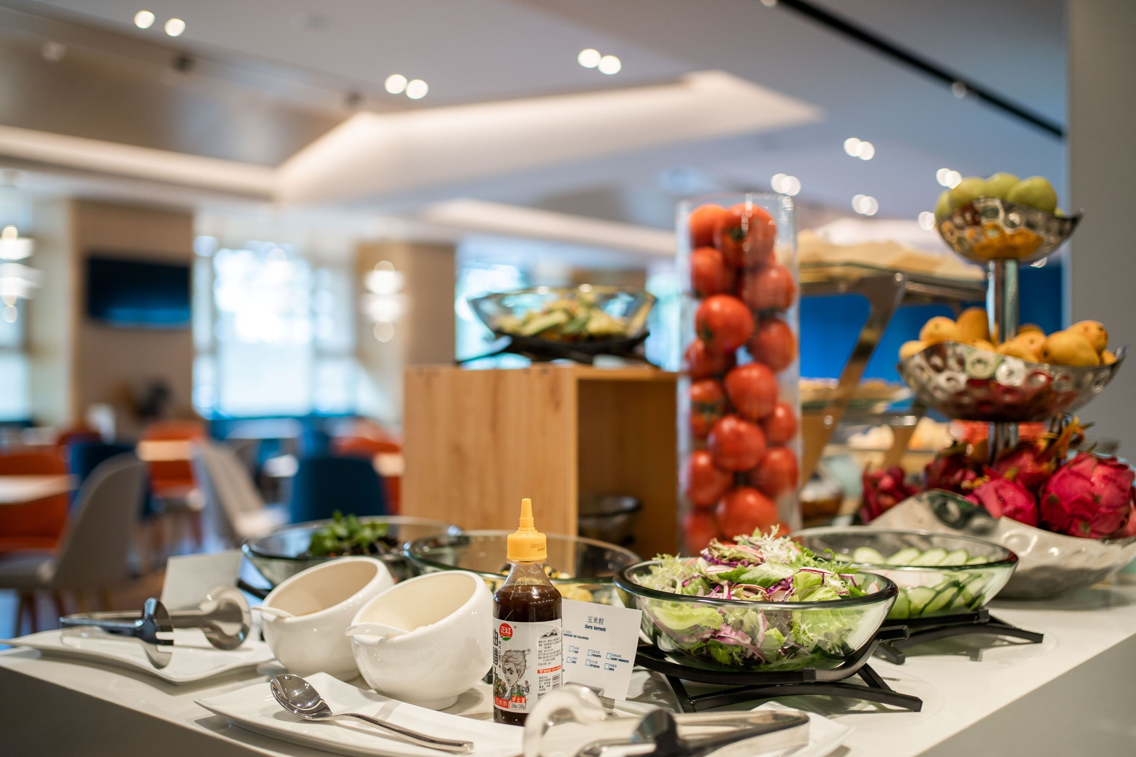 Uma mesa de buffet com diversos alimentos e acompanhamentos.