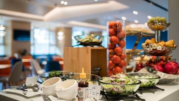 A buffet table with various food items and condiments.