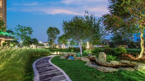 A landscaped garden with a winding path, a pond, and a building with a sign that reads "Inn Express." - Holiday Inn Express Guangzhou Panyu by IHG (Guangzhou)