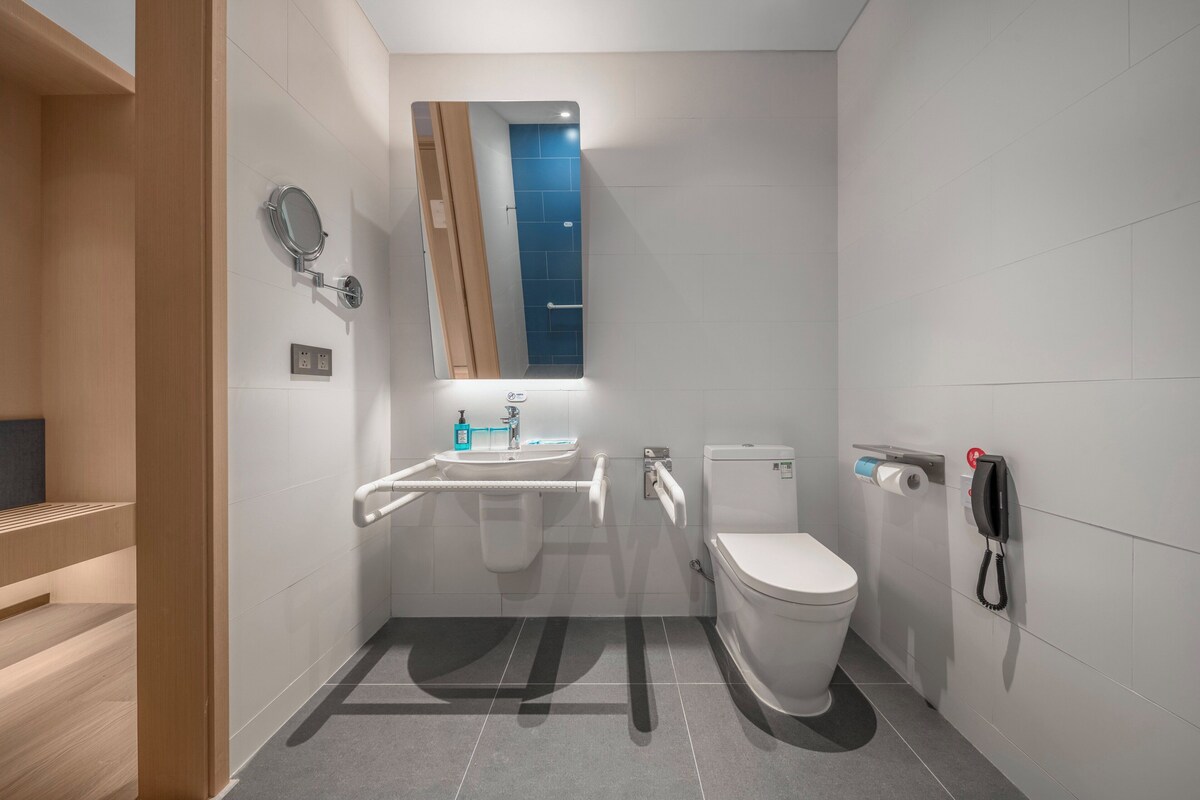 Een moderne badkamer met toilet, wastafel en spiegel.
