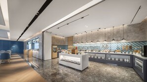 A modern kitchen with a marble countertop, a buffet area, and a seating area with blue chairs. - Holiday Inn Express Guangzhou Panyu by IHG (Guangzhou)