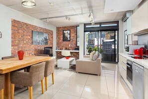 Una cocina moderna con comedor, sofá y televisor.