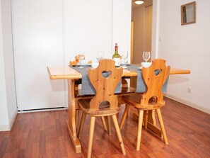 Un tavolo da pranzo con quattro sedie di legno, una bottiglia di vino e alcuni bicchieri.