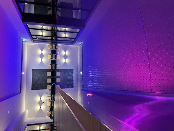 A modern interior with a glass ceiling, reflective surfaces, and a central seating area. - Rebhans Business und Wellness Hotel (Stockheim)
