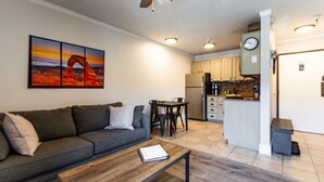 Una sala de estar con un sofá, una mesa de centro y un cuadro en la pared.
