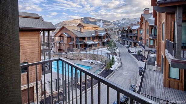 A resort with multiple wooden buildings, a central pool, and a view of snow-capped mountains. - Stunning! Walk to lift - Beautiful pool complex (Park City)