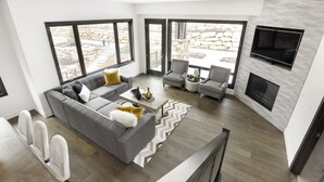 A modern living room with a gray sectional sofa, a coffee table, and a fireplace. - Stunning! Walk to lift - Beautiful pool complex (Park City)