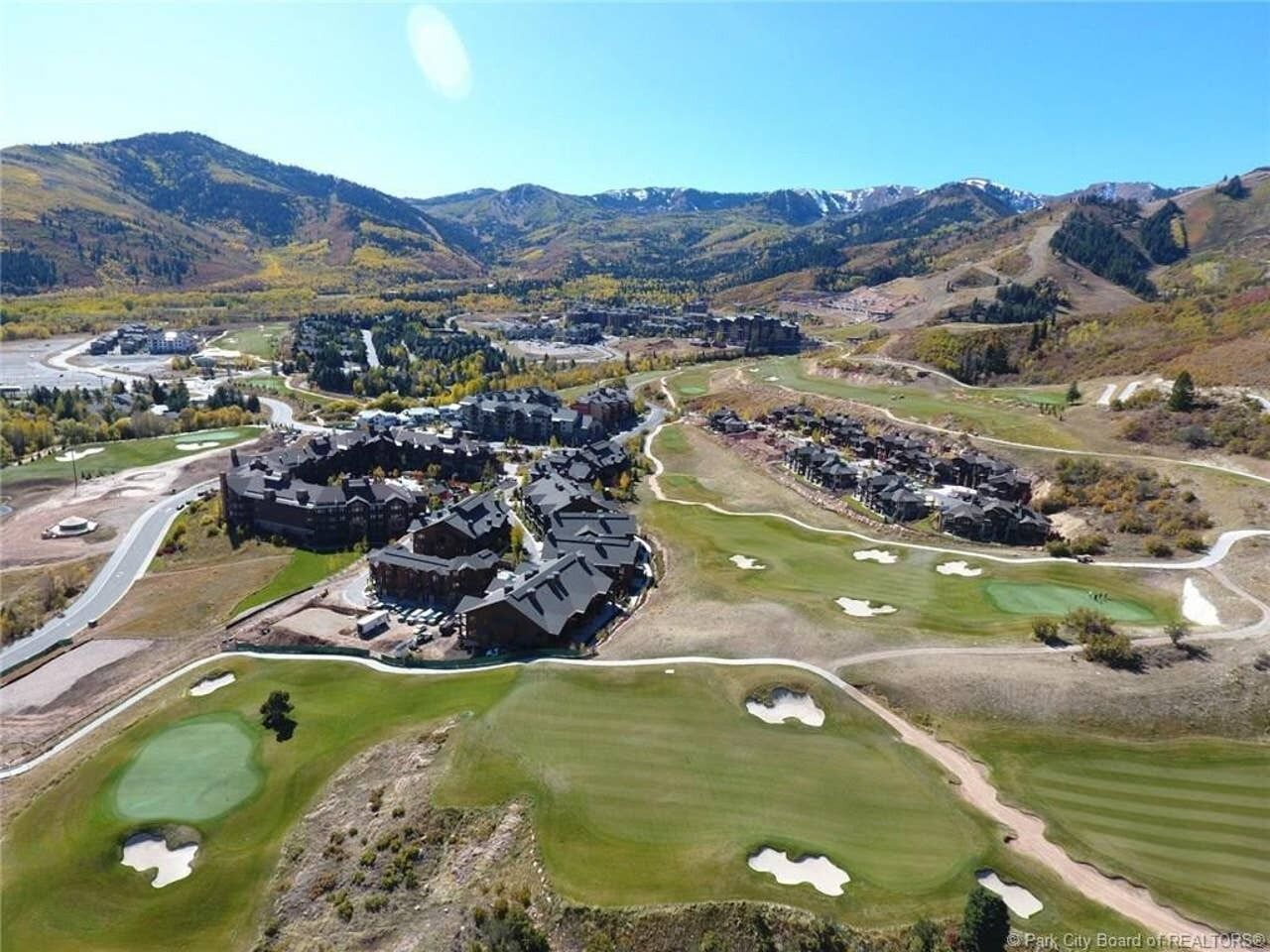 A golf course with bunkers and a clubhouse.