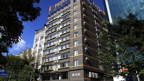 Un hôtel à plusieurs étages, doté d’une façade moderne, de nombreux balcons et d’une enseigne indiquant qu’il s’agit d’un hôtel.