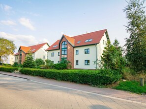 Ein Wohngebiet mit modernen Häusern, einer gepflasterten Straße und gepflegter Bepflanzung.
