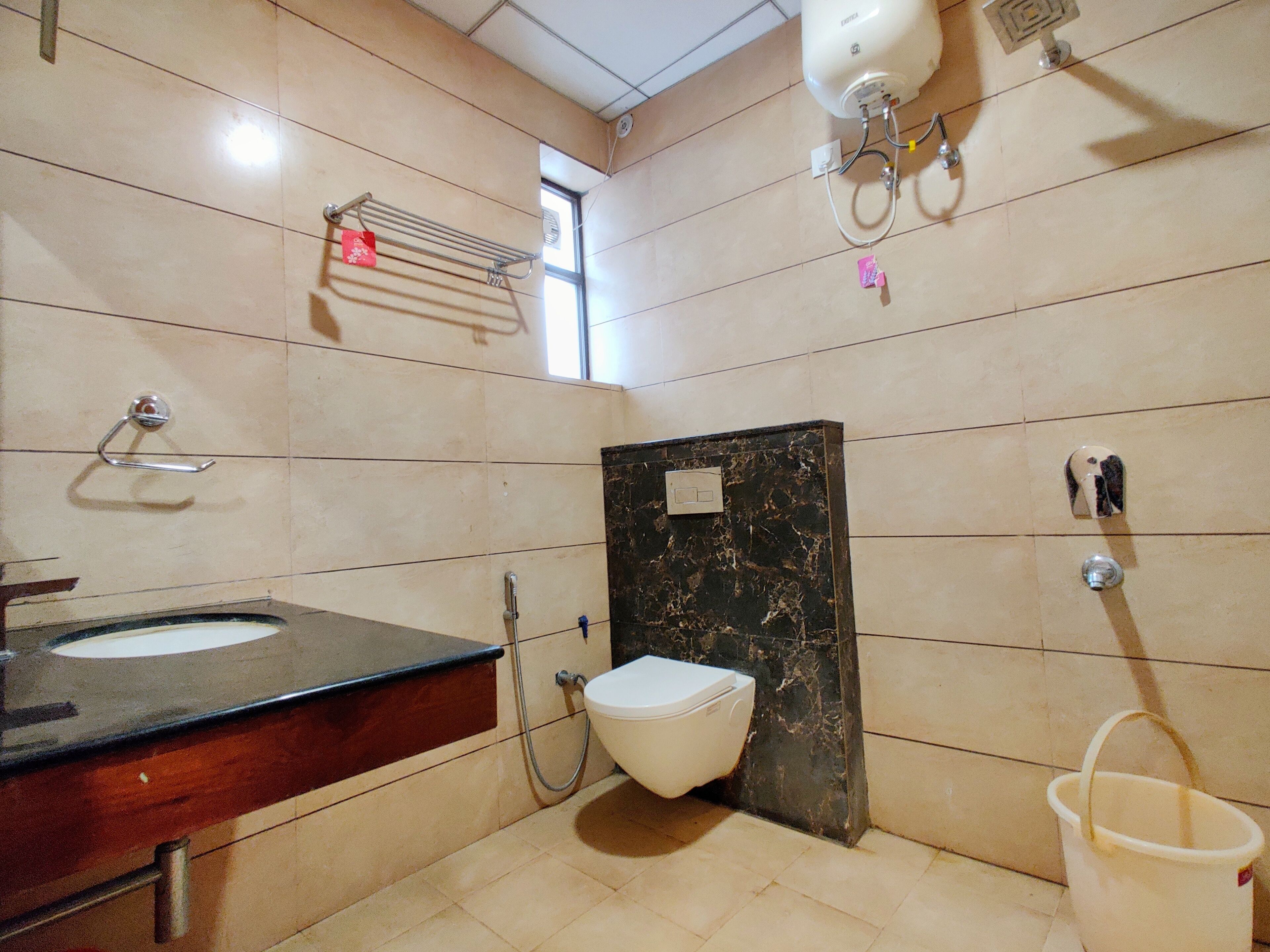 Un bany amb un lavabo, vàter i plat de dutxa.